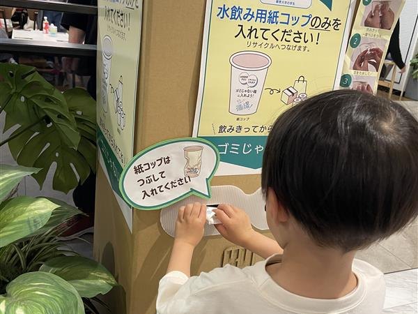 商業施設に設置した回収BOXに紙コップを入れる来場者